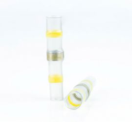 Twee gele, warmtekrimpende, soldeerverbinders, geïsoleerd, één rechtop staand en één liggend, op een witte achtergrond.